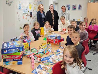 Kinder und Erzieherinnen am Spieletisch