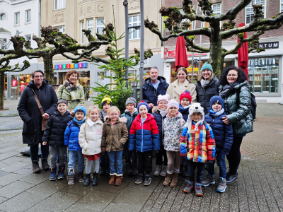 Kinder und Erwachsene vor Weihnachtsbaum