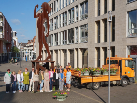 Bürgermeisterin Sabine Anemüller (rechts) präsentiert die neuen Blumenampeln zusammen mit Mitarbeitenden der Städtischen Betriebe und Repräsentierenden der Sponsoren und Partnerunternehmen