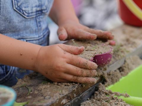 Kinderhände spielen mit Sand